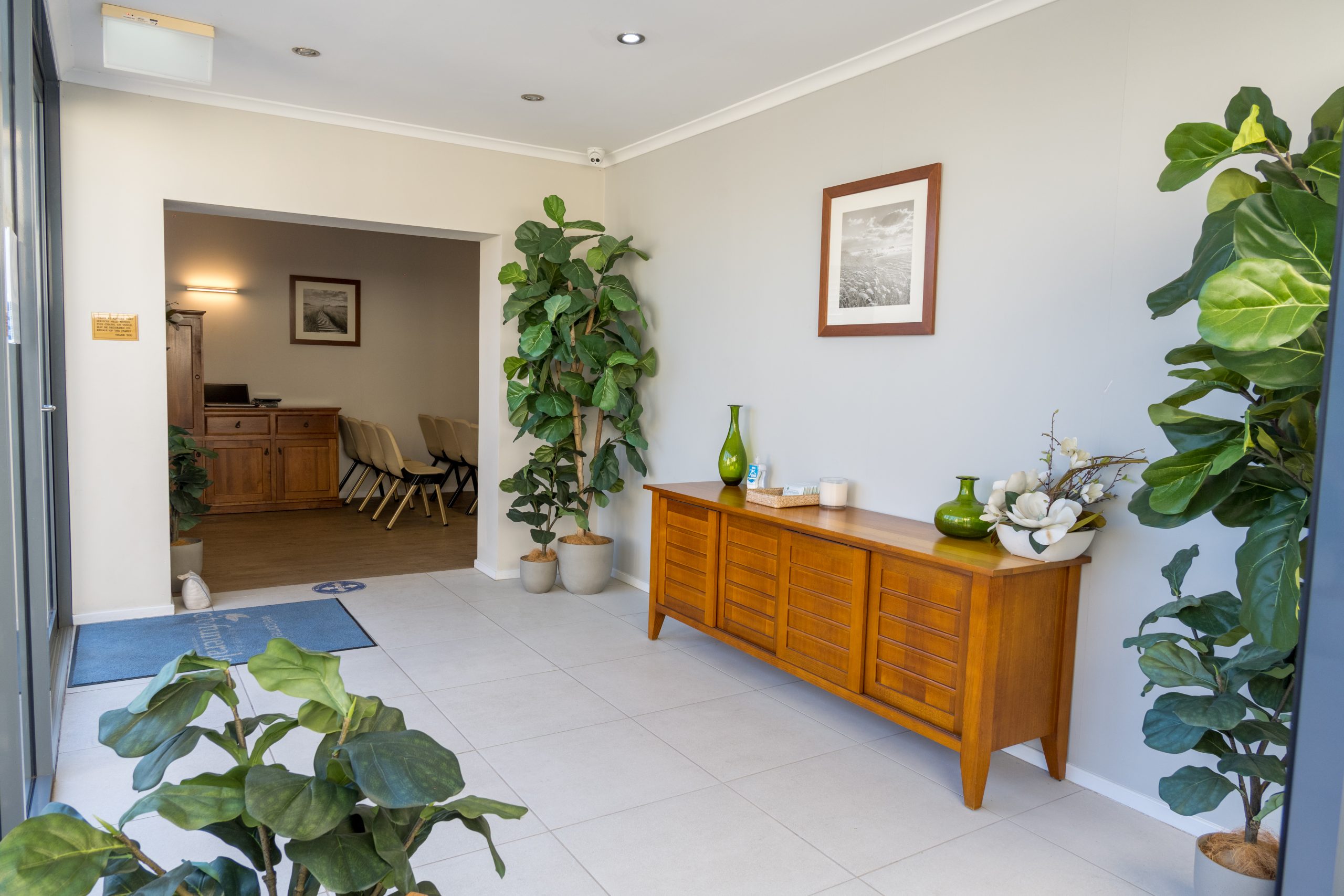 Chapel foyer with greenery, wooden furnishings and seating area